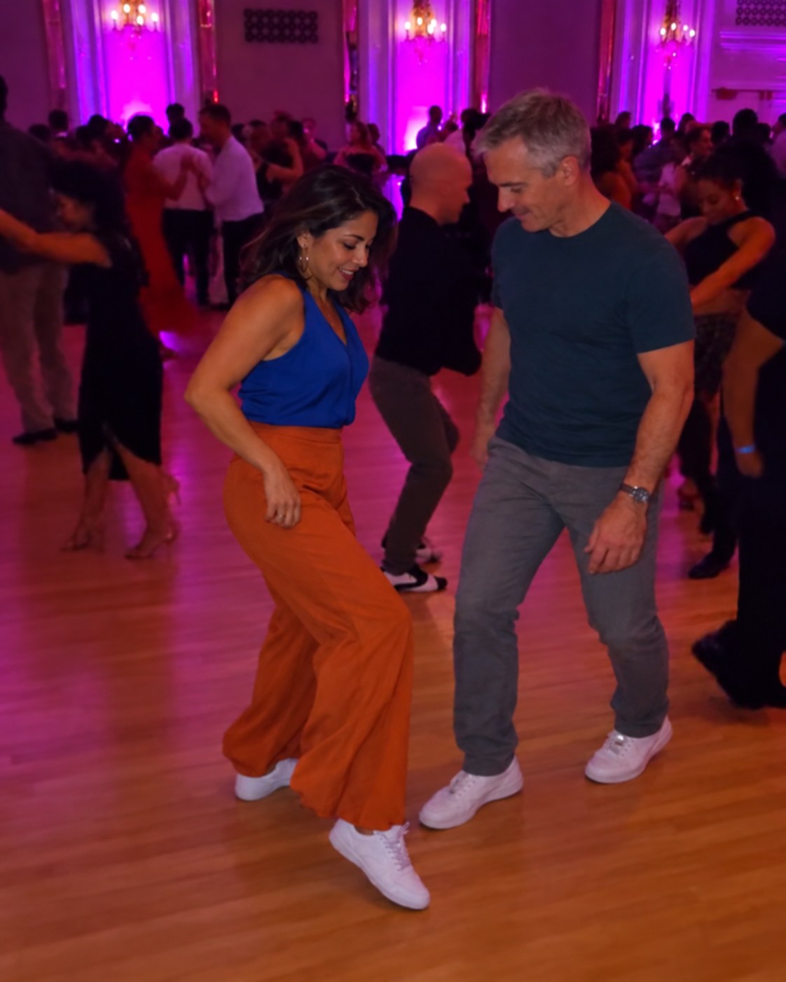 Two adult partners dancing in a purple-lit ballroom, with an example Dance Eye Pro note over the image.